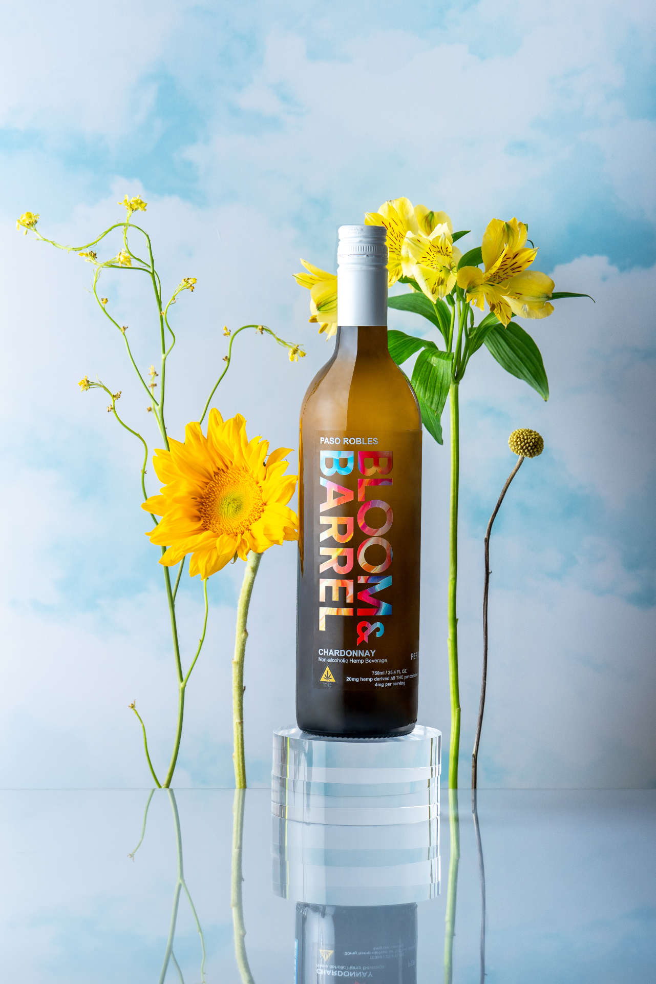 Bloom & Barrel Chardonnay bottle with yellow flowers against a sky background