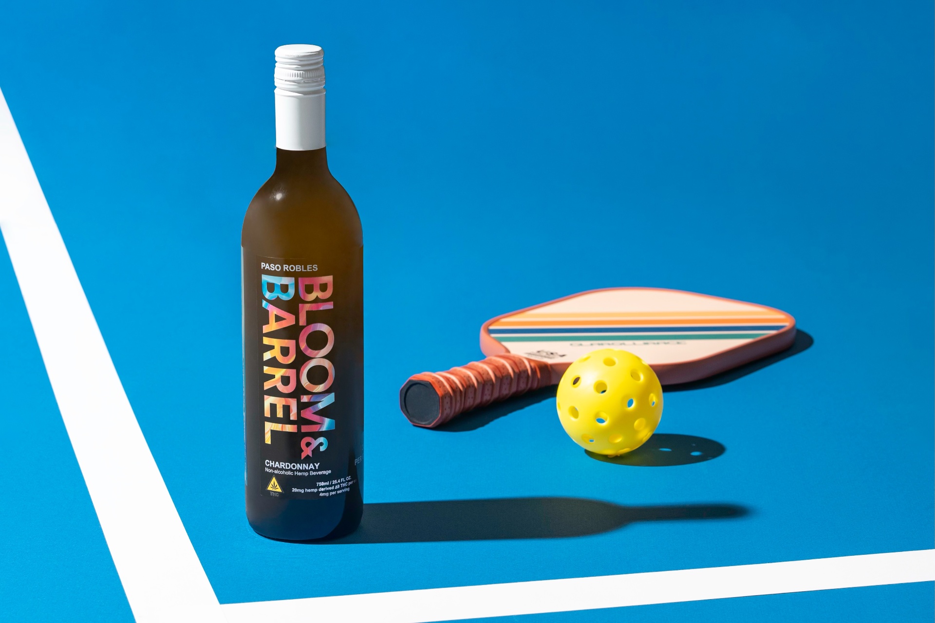 Bloom & Barrel Chardonnay bottle on a pickleball court