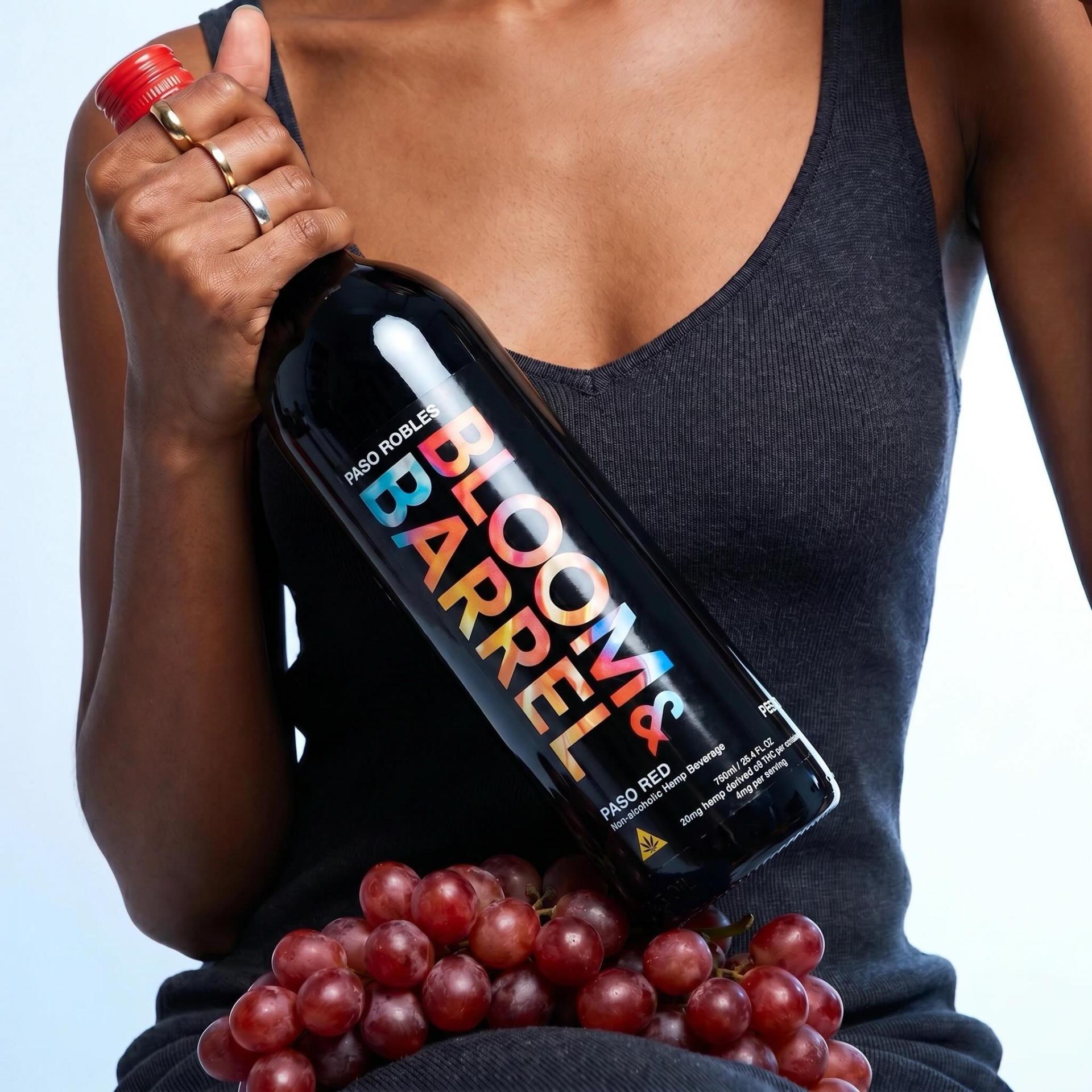 Bloom & Barrel Paso Red bottle held with fresh grapes